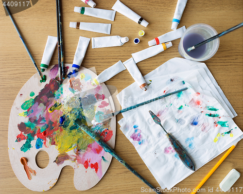 Image of palette knife, brushes and paint tubes on table