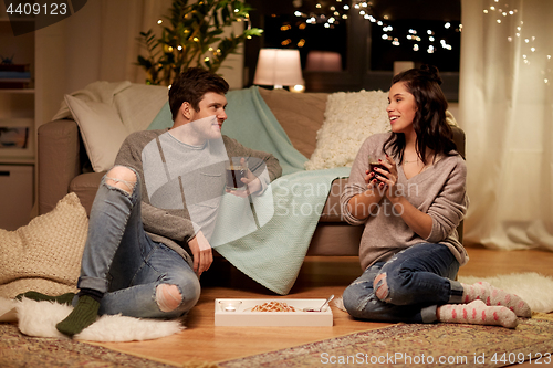 Image of happy couple drinking coffee and eating at home