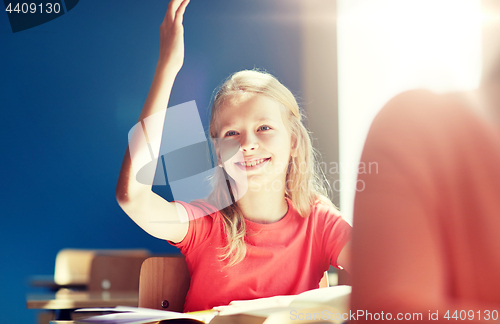 Image of happy student girl raising hand at school lesson