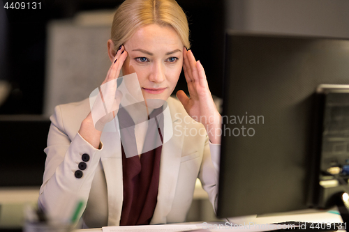 Image of businesswoman with computer at night office
