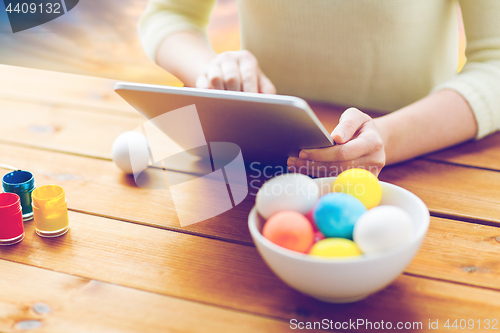 Image of close up of woman with tablet pc and easter eggs