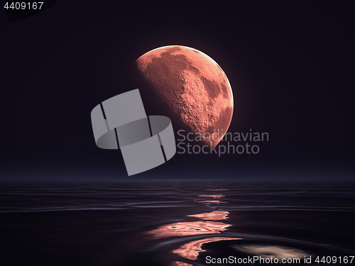 Image of red moon rising over the ocean