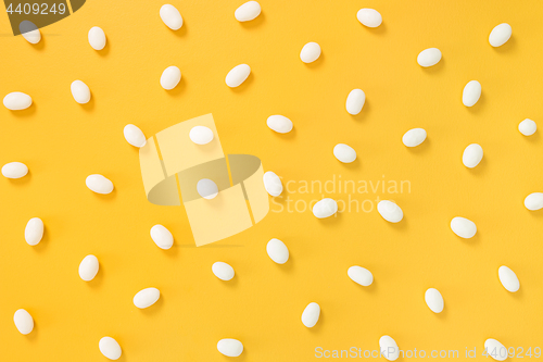 Image of White chocolate candies on yellow background