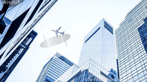 Image of a plane flying over modern buildings of New York City
