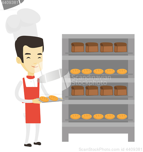 Image of Happy young male baker holding tray of bread.