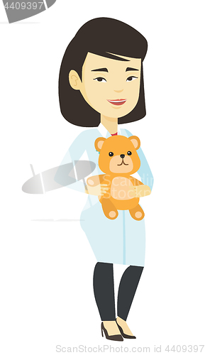 Image of Pediatrician doctor holding teddy bear.