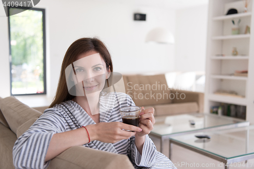 Image of young woman in a bathrobe enjoying morning coffee