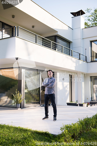 Image of man in front of his luxury home villa