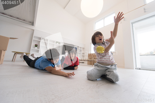 Image of boys having fun with an apple on the floor