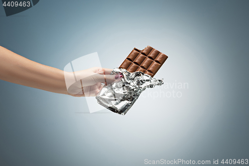 Image of Hands of a woman holding a tile of chocolate