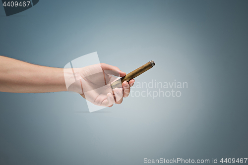 Image of Cuban unlit cigar in male hand