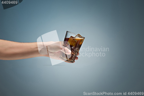 Image of Drink cola in glass with hand