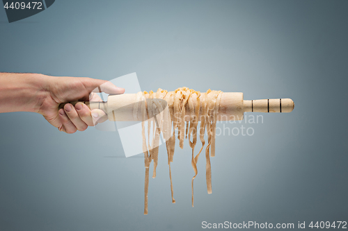 Image of Male hand holding Raw spaghetti