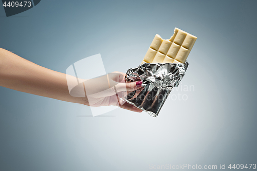 Image of Hands of a woman holding a tile of chocolate