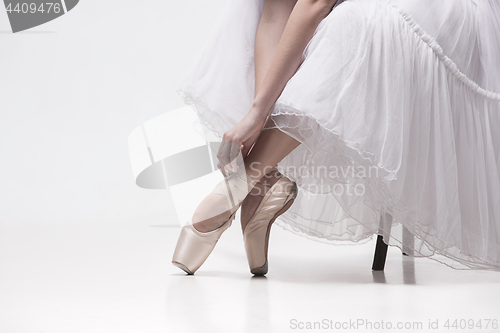 Image of The teen ballerina in white pack sitting on chair