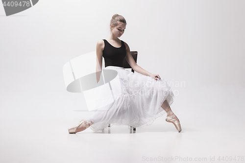 Image of The teen ballerina in white pack sitting on chair