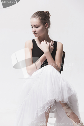 Image of The teen ballerina in white pack sitting on chair