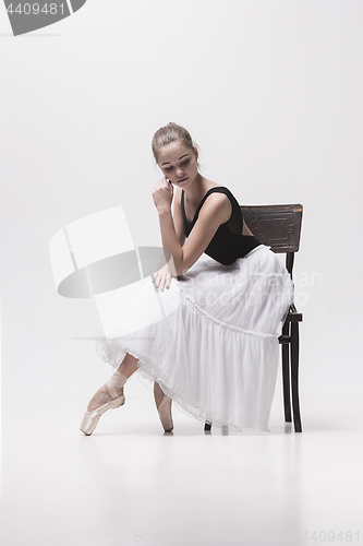 Image of The teen ballerina in white pack sitting on chair