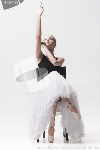 Image of The teen ballerina in white pack sitting on chair