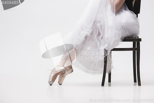 Image of The teen ballerina in white pack sitting on chair