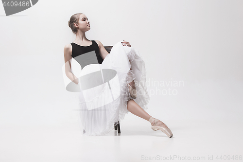 Image of The teen ballerina in white pack sitting on chair