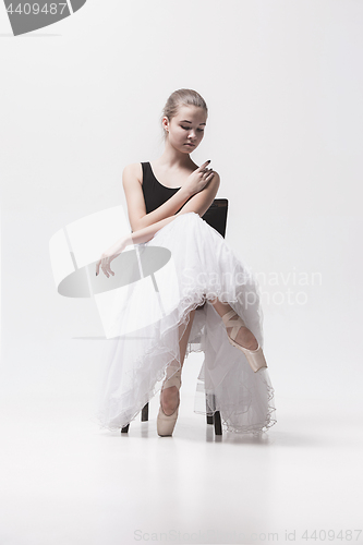 Image of The teen ballerina in white pack sitting on chair