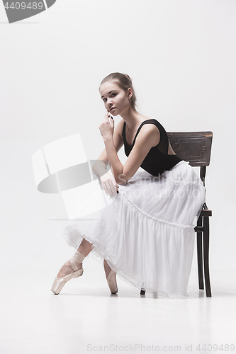Image of The teen ballerina in white pack sitting on chair
