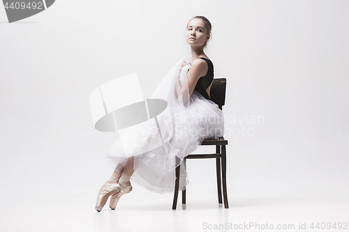 Image of The teen ballerina in white pack sitting on chair