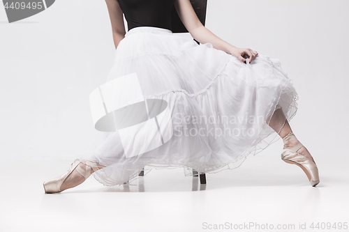 Image of The teen ballerina in white pack sitting on chair