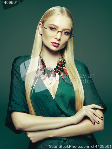 Image of Blonde young woman in elegant green dress.