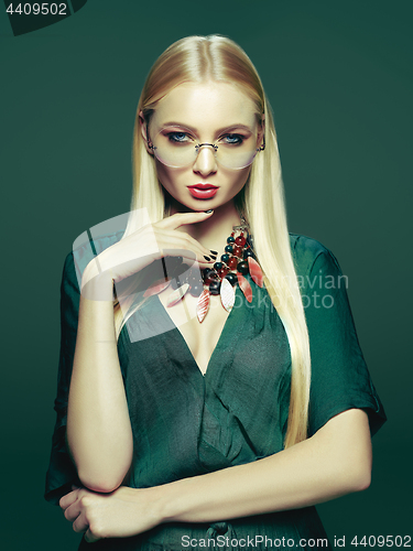 Image of Blonde young woman in elegant green dress.