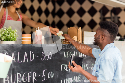 Image of african american man paying money at food truck