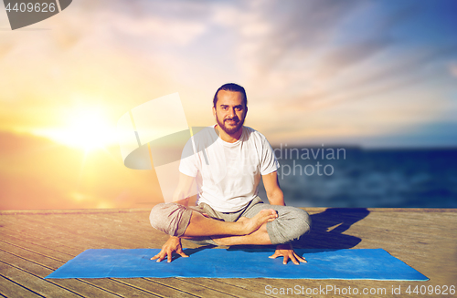 Image of man doing yoga scale pose outdoors