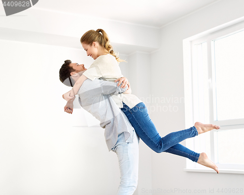 Image of happy couple at empty room of new home