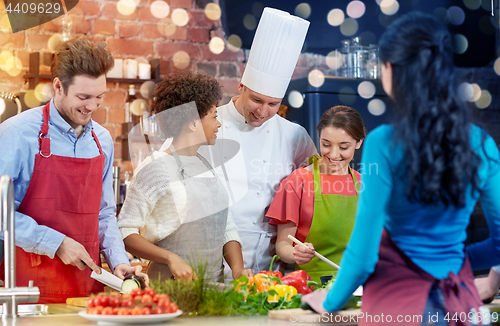 Image of happy friends and chef cook cooking in kitchen