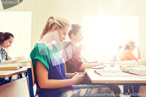 Image of student girl with smartphone texting at school