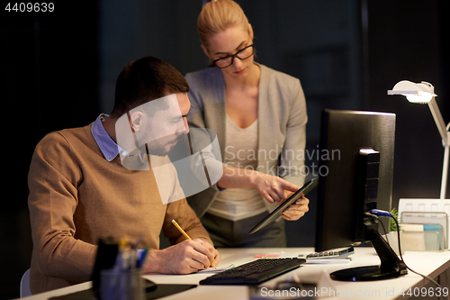 Image of business team with tablet pc at night office