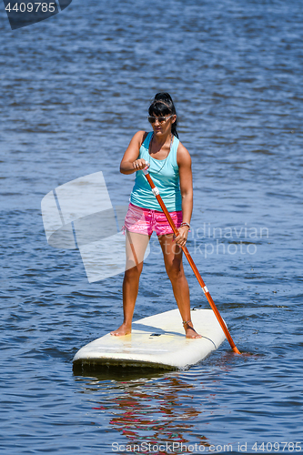 Image of Woman stand up paddleboarding