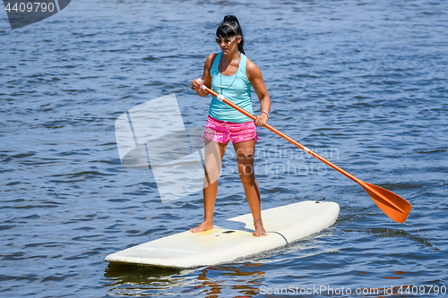 Image of Woman stand up paddleboarding