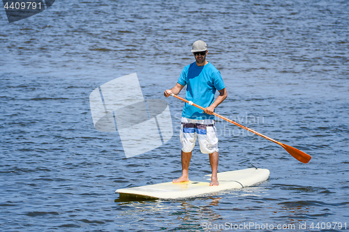 Image of Man stand up paddleboarding
