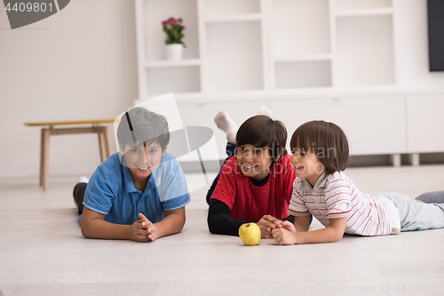 Image of boys having fun with an apple on the floor