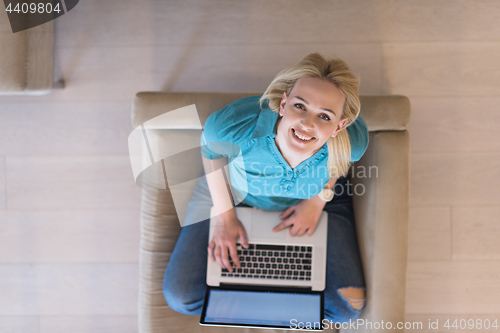 Image of Young woman using laptop at home top view