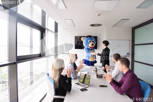 Image of boss dresed as bear having fun with business people in trendy of