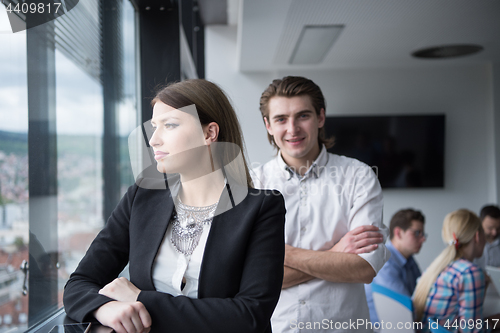 Image of Elegant Woman Using Mobile Phone by window in office building