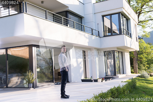 Image of man in front of his luxury home villa