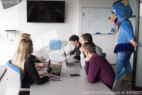 Image of boss dresed as bear having fun with business people in trendy of