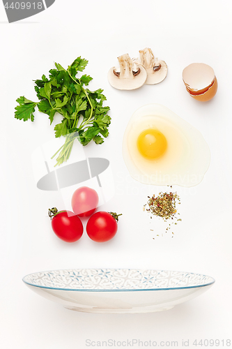 Image of The falling ingredients of fried egg. Healthy breakfast ingredients.