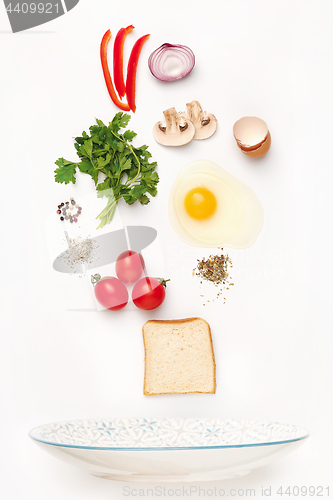 Image of The falling ingredients of fried egg. Healthy breakfast ingredients.