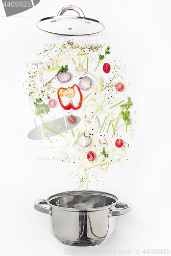 Image of Assorted fresh vegetables falling into a bowl, on white background