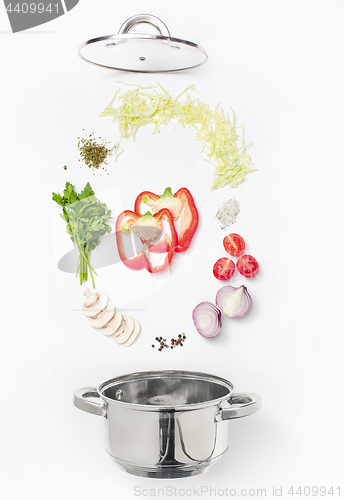 Image of Assorted fresh vegetables falling into a bowl, on white background